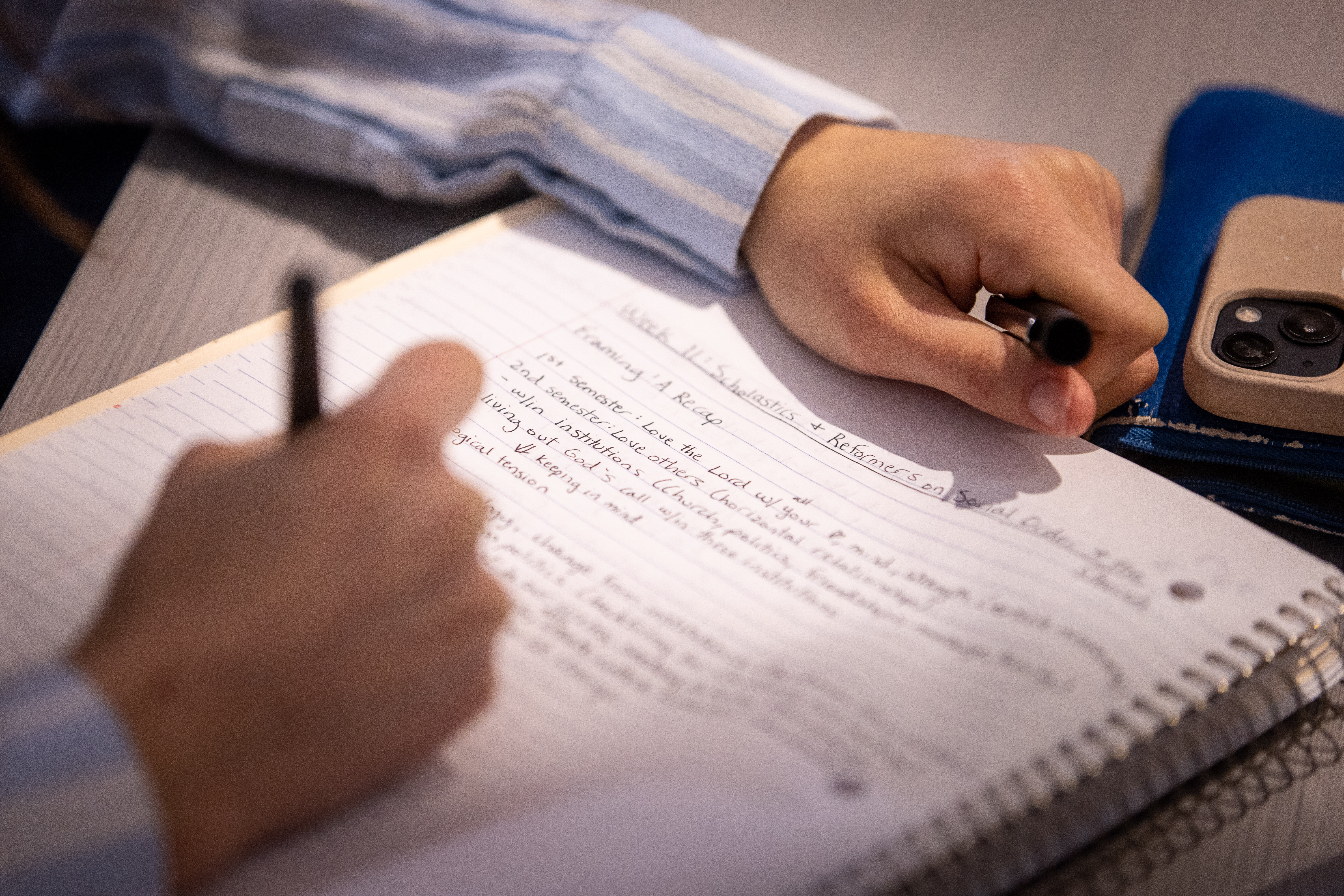 student writing down notes